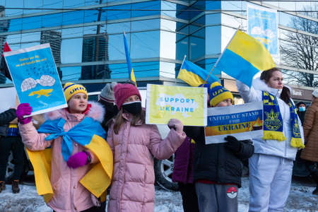 Toronto, ON, Canada â€“ February 25, 2022:   Protestors with banners and Ukrainian flags in...