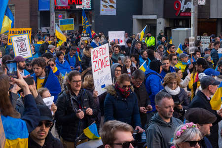 Toronto, Ontario, Canada â€“ March 6, 2022:  Demonstrators with yellow and blue Ukraine flags...