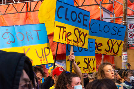 Toronto, Ontario, Canada â March 6, 2022:  Demonstrators with yellow and blue Ukraine flags and anti-war signs near Russian consulate in Toronto ask to close the airspace over Ukraine during the war in Ukraineのeditorial素材