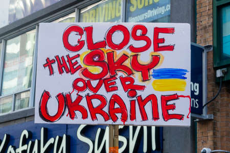 Toronto, Ontario, Canada â March 6, 2022:  Demonstrators with yellow and blue Ukraine flags and anti-war signs near Russian consulate in Toronto ask to close the airspace over Ukraine during the war in Ukraineのeditorial素材