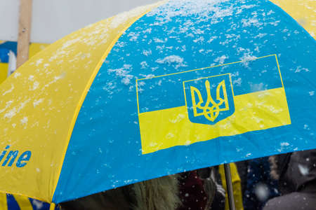Toronto, ON, Canada â February 25, 2022:    An umbrella in the yellow and blue colors of the flag of Ukraine as a symbol of the country's defense against bombing during the demonstration "Close the flight zone over Ukraine" near the US Consulate in Toroのeditorial素材