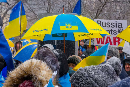 Toronto, ON, Canada â February 25, 2022:    An umbrella in the yellow and blue colors of the flag of Ukraine as a symbol of the country's defense against bombing during the demonstration "Close the flight zone over Ukraine" near the US Consulate in Toroのeditorial素材