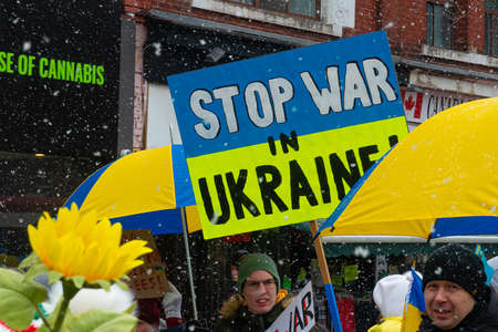 Toronto, ON, Canada â April 10, 2022:  Protestors with banners and Ukrainian flags in Downtown Nathan Phillips Square during the  rally to stop the genocide of Ukrainians.のeditorial素材