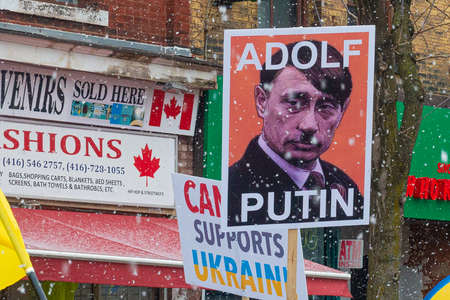 Toronto, ON, Canada â April 10, 2022:  Protestors with banners and Ukrainian flags in Downtown Nathan Phillips Square during the  rally to stop the genocide of Ukrainians.のeditorial素材