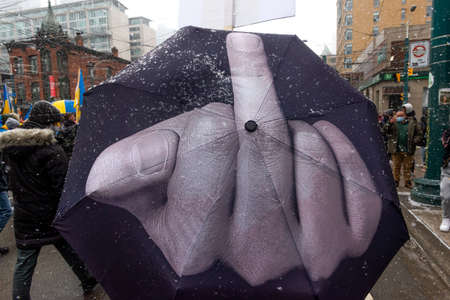 Toronto, ON, Canada â€“ April 10, 2022:  Protestors with banners and Ukrainian flags in...