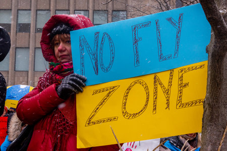 Toronto, ON, Canada â April 10, 2022:  Protestors with banners and Ukrainian flags in Downtown Nathan Phillips Square during the  rally to stop the genocide of Ukrainians.のeditorial素材