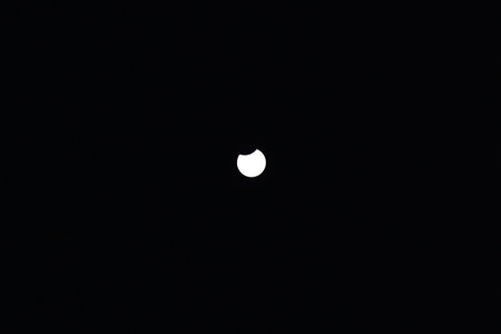 Toronto, ON, Canada - April 8, 2024: Partial solar eclipse 2024 seen from a cloudy sky near Toronto in Canadaの写真素材