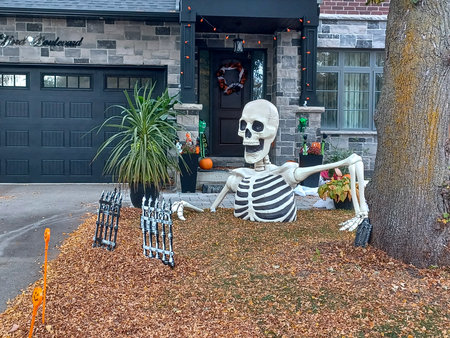 Toronto, ON, Canada - October 31, 2024: A two-storey home features glowing Halloween inflatables on...