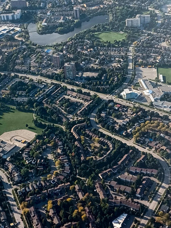 Mississauga, ON, Canada â September 26, 2024: A plane flies over suburban Mississauga, revealing parks, homes, and mid-rise buildings surrounded by greenery.の写真素材