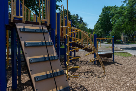 a sunny day scene of a colorful playground with slides, ladders, and climbing frames surrounded by...