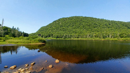View at the Jacques Cartier lake in Quebec with reflects in the clear water, showcasing summer nature and wilderness.の写真素材