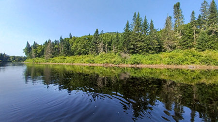 View at the Jacques Cartier lake in Quebec with reflects in the clear water, showcasing summer...