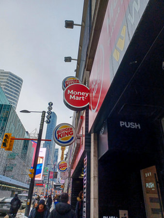 Toronto, ON, Canada - September 18, 2025: Bright Money Mart and Burger King signs illuminate the downtown cityscape.のeditorial素材