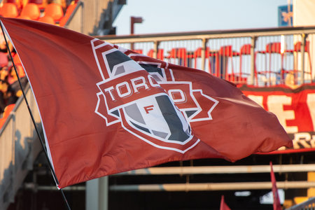 Toronto, ON, Canada - September 19, 2025: A fan waves a Toronto FC flag at a match in a soccer...