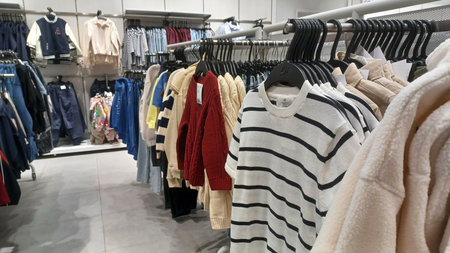 Toronto, ON, Canada - January 5, 2026: Various jackets, shirts, and trousers hang on metal racks in...