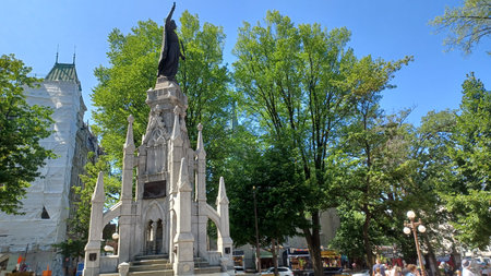 Montreal, QC, Canada - August 7, 2025: Samuel De Champlain monument standing tall in a prominent public square, surrounded by lush green trees and historic architectureのeditorial素材
