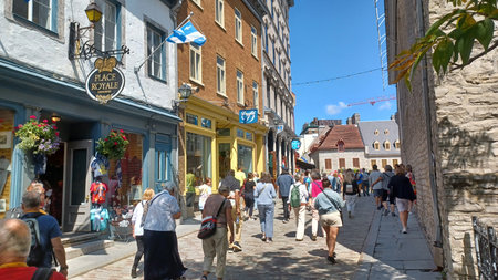 Montreal, QC, Canada - August 7, 2025: Tourists exploring a charming cobblestone street lined with historic buildings and shops in Old Quebec City, Canadaのeditorial素材