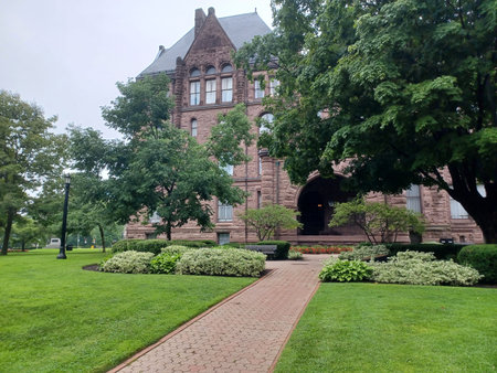 âToronto, ON, Canada - September 3, 2025: A brick path leads toward the historic Queens Park building surrounded by lush green lawns and landscaping on a cloudy day.のeditorial素材