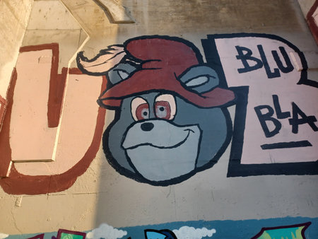 Toronto, ON, Canada - june 25, 2025: Colorful cartoon graffiti art covers the concrete support pillar of a bridge or overpass in a natural, overgrown area.のeditorial素材