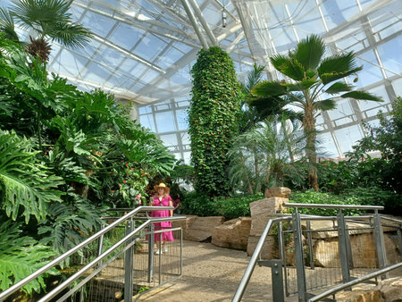 Niagara Falls, ON, Canada - August 4, 2025: Woman in a pink dress enjoys walking through the Butterfly Conservatory.のeditorial素材