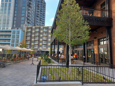 Charlotte, NC, USA - June 9, 2025: Outdoor dining area shows a busy street in uptown Charlotte. The day is sunny and people enjoy the weather.のeditorial素材