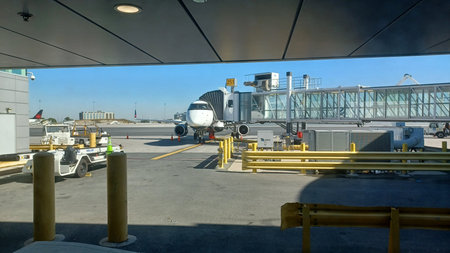 Charlotte, NC, USA - June 9, 2025: An airplane waits at the gate with a jet bridge connected, ready...