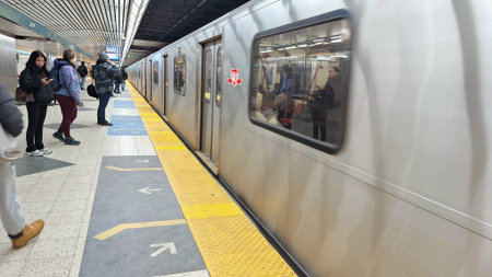 Toronto, ON, Canada - March 14, 2026: Commuters are waiting on subway platform for the next train to...