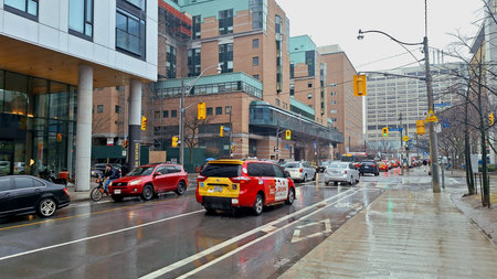 Toronto, ON, Canada - March 26, 2026: A rainy day in the city shows cars and a cyclist moving...