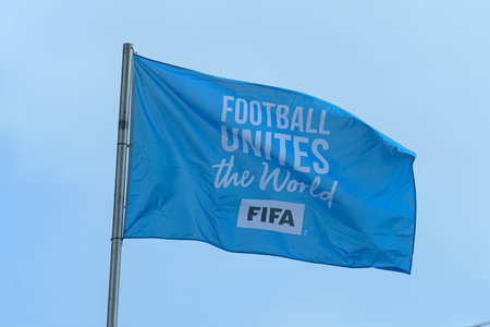 A blue FIFA flag is shown against a blue sky background.