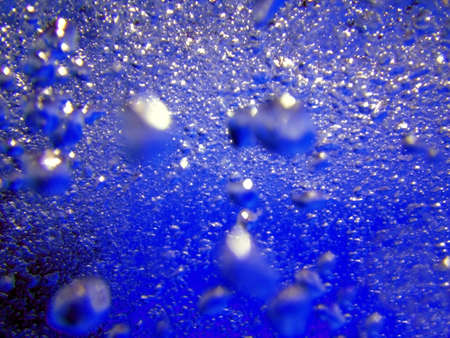 Water in the swimming pool is blue. Background. Details about water. Drops of water. Blurred. Shadedの写真素材