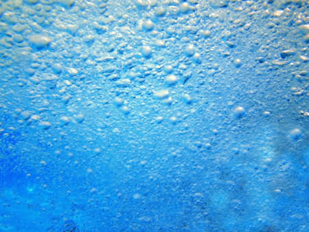 Water in the swimming pool is blue. Background. Details about water. Drops of water. Blurred. Shadedの写真素材