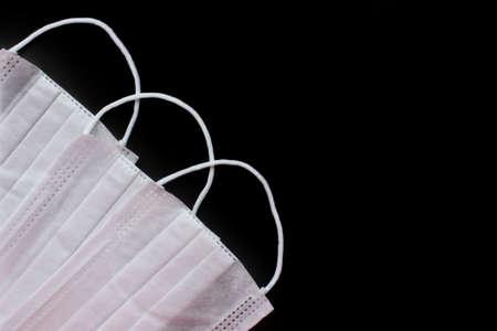 Medical mask for virus protection. Disposable mask. On a black background.