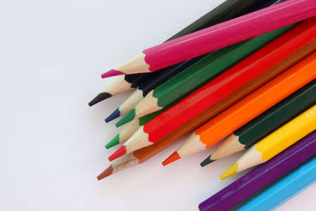 Colored pencils white background. Lots of different colored pencils. Colored pencil. Pencils are sharp. Pencils lie on the left. Close-up. Copy space. Background. Flat lay.の写真素材