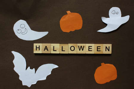Word Halloween. Wooden blocks with an inscription on black background decorated with bats, pumpkin...