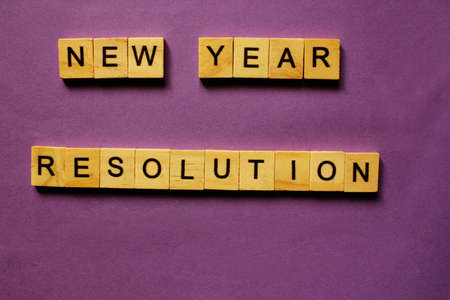 Words New Year Resolution. Wooden blocks with inscription on purple background. The bulletin board. Concept of holiday-Christmas and New year. View from above. Copy space for Text. New Year.の写真素材