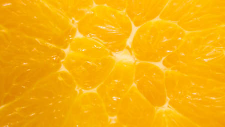 A slice of orange close-up. The background is made of citrus fruits. Pieces of citrus. Texture....