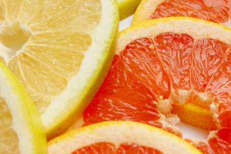 Grapefruit, orange, lime, tangerine, lemon slices. The background is made of citrus fruits. Pieces of citrus. The background is of multi-colored citrus fruits. Texture. Wallpapers. Vitamin Complexの写真素材