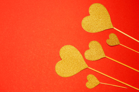 Five hearts of yellow on a red background. View from above. Hearts are on the right. Concussion is love. Valentine's Day. Romance. Background. Texture. Copy space. Flatlayの写真素材