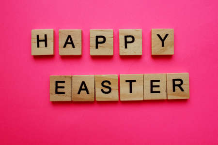Easter, the word in the wooden letters of the alphabet. Isolated on a yellow background. Easter...