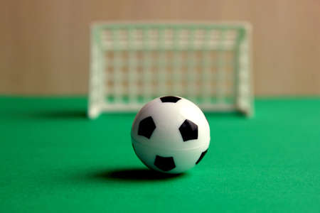 Football. A football in a small gate on a gray background. Mini football. Sports game. The ball is near the gate. Copy the space. Healthy, active outdoor playの写真素材