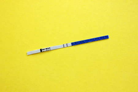 Positive pregnancy test on a yellow background. Motherhood, children, pregnancy, the concept of...