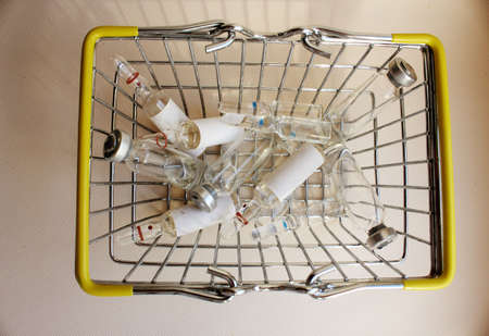 Basket with ampoules of drugs for injection. vaccination. The concept of medicine and immunity. Vaccination against viral infections. Drug and injection. cold. Injection, drug.の写真素材