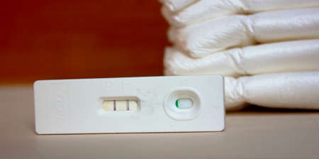Positive pregnancy test and diapers. Motherhood, children, pregnancy, the concept of birth control....