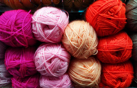 Knitted pattern of multi-colored wool yarn on the shop window. Background for knitting. Knitting...
