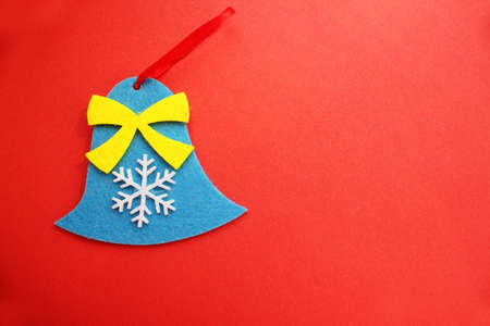 Christmas tree toys on a red background. Toy in the form of a bell. Top view. Christmas and New Year. Toys on the Christmas tree. Childhood. Felt toys. Copy spaceの写真素材