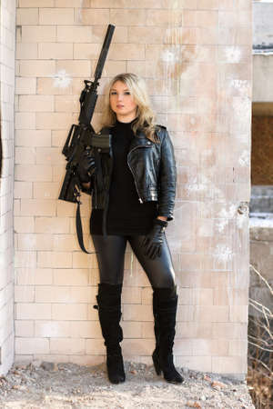 Portrait of young beautiful woman with a gun