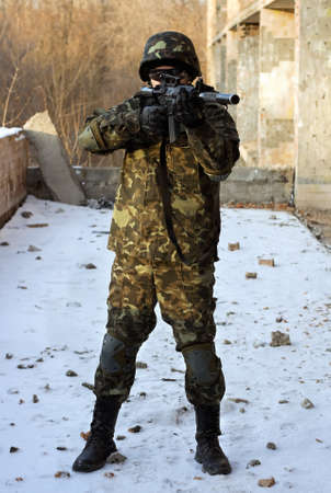 Soldier in camouflage with rifle in his hands