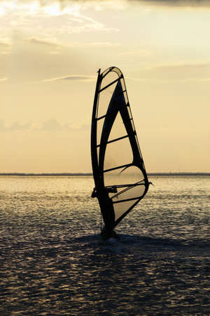 Silhouette of a windsurfer on the sea bay surfaceの写真素材