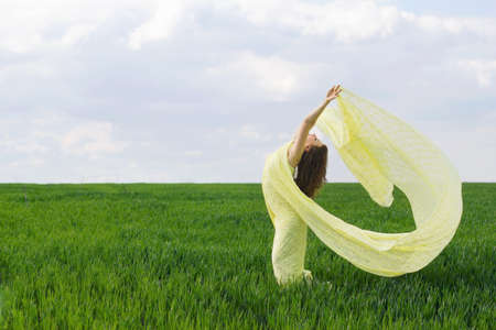 Cute girl dancing in a green field
