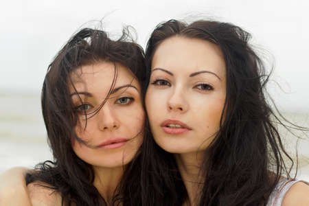 Closeup portrait of a two young women on the beachの写真素材